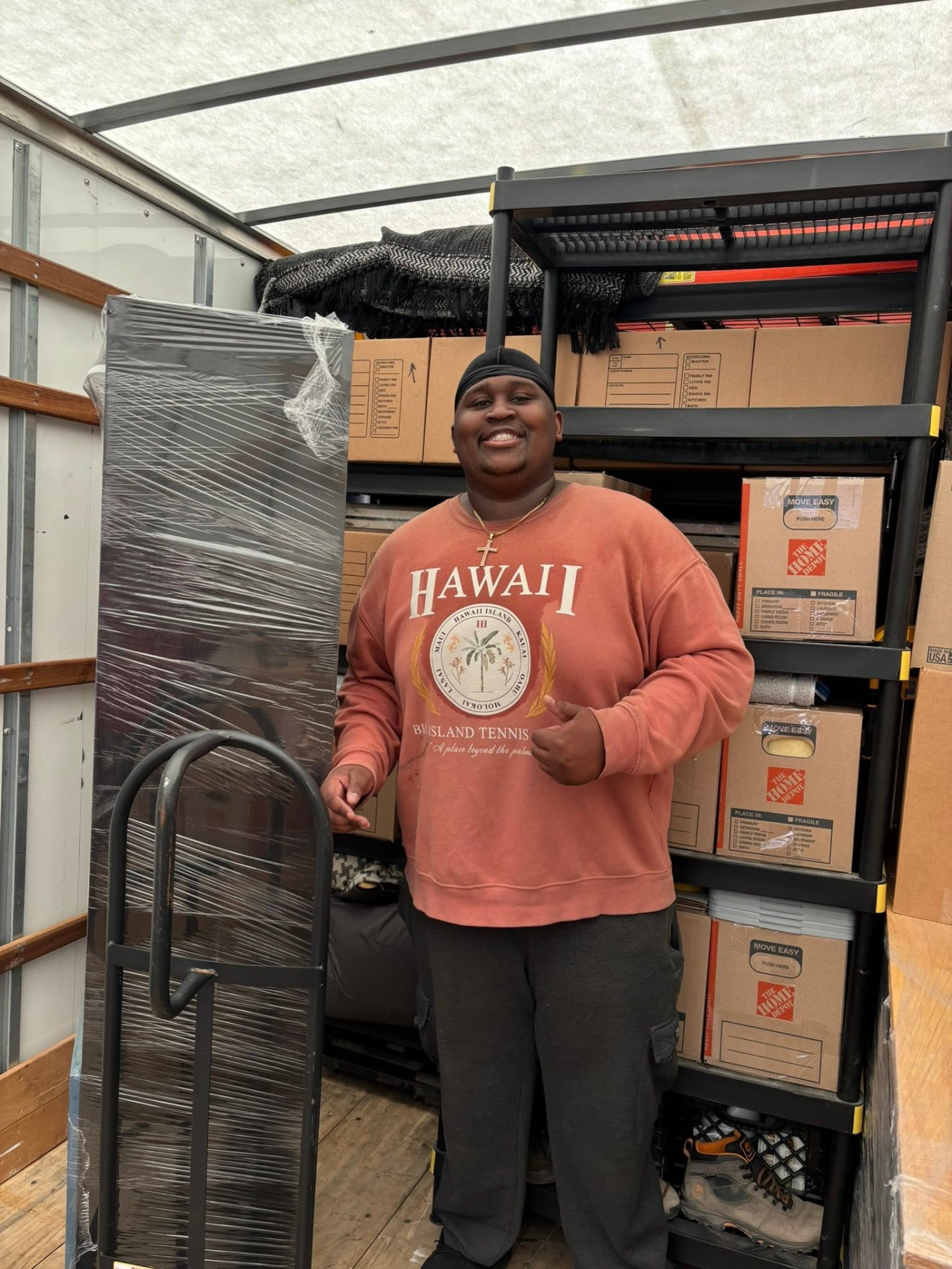 Big Guy Moving crew member with shrink-wrapped furniture inside the moving truck
