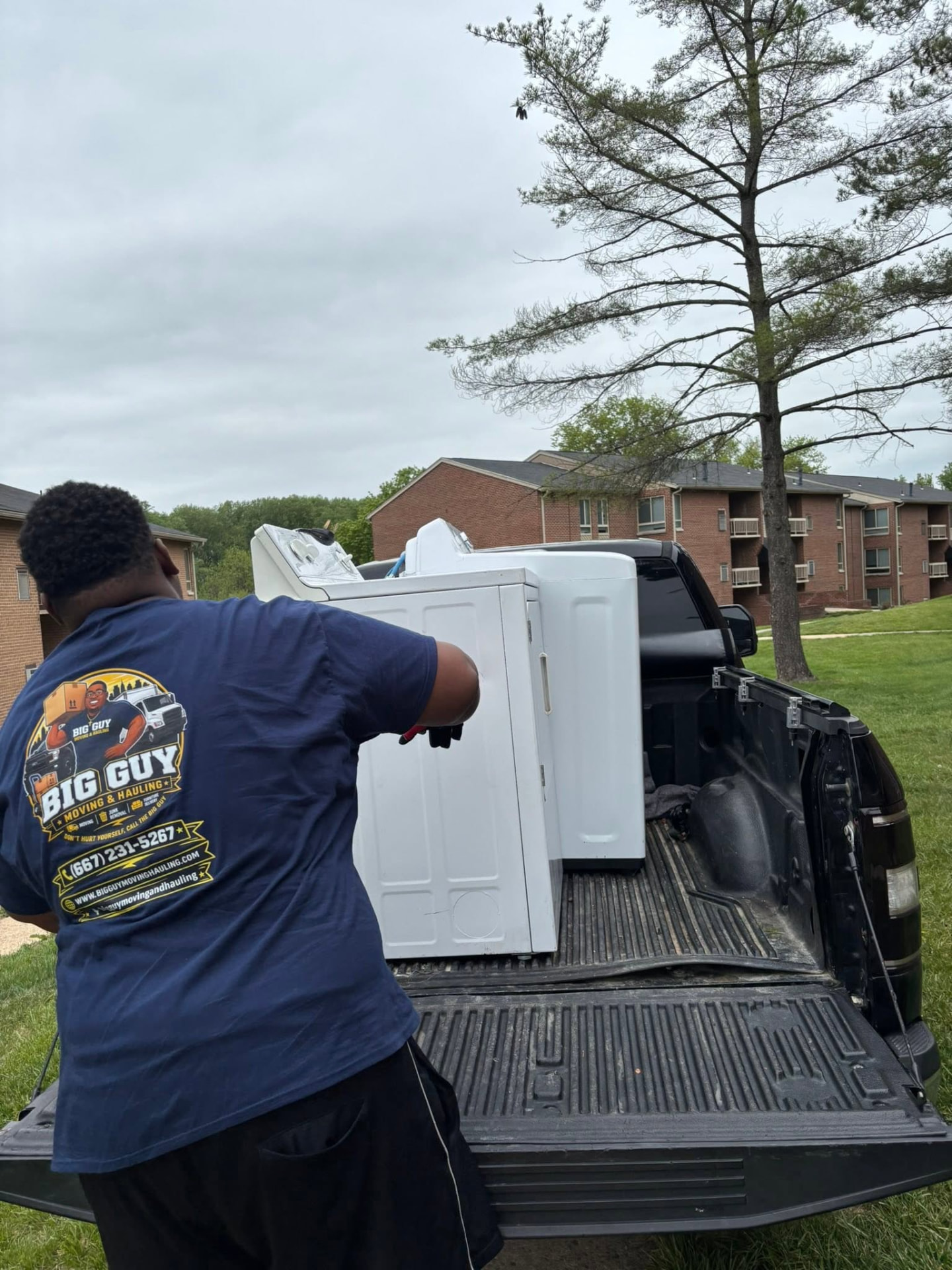 Big Guy Moving & Hauling crew loading a washer and dryer into a truck bed