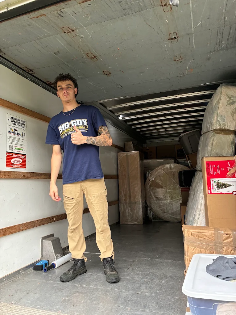 Crew member in a Big Guy Moving shirt inside the truck