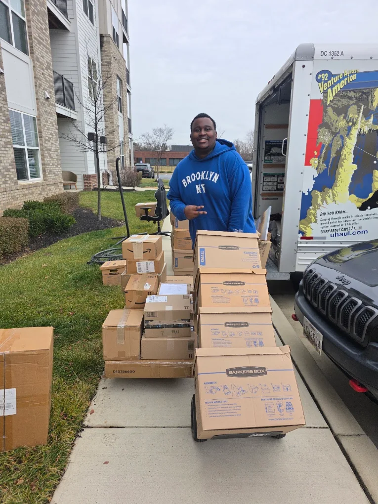 Aaron with a stacked dolly of boxes at an apartment