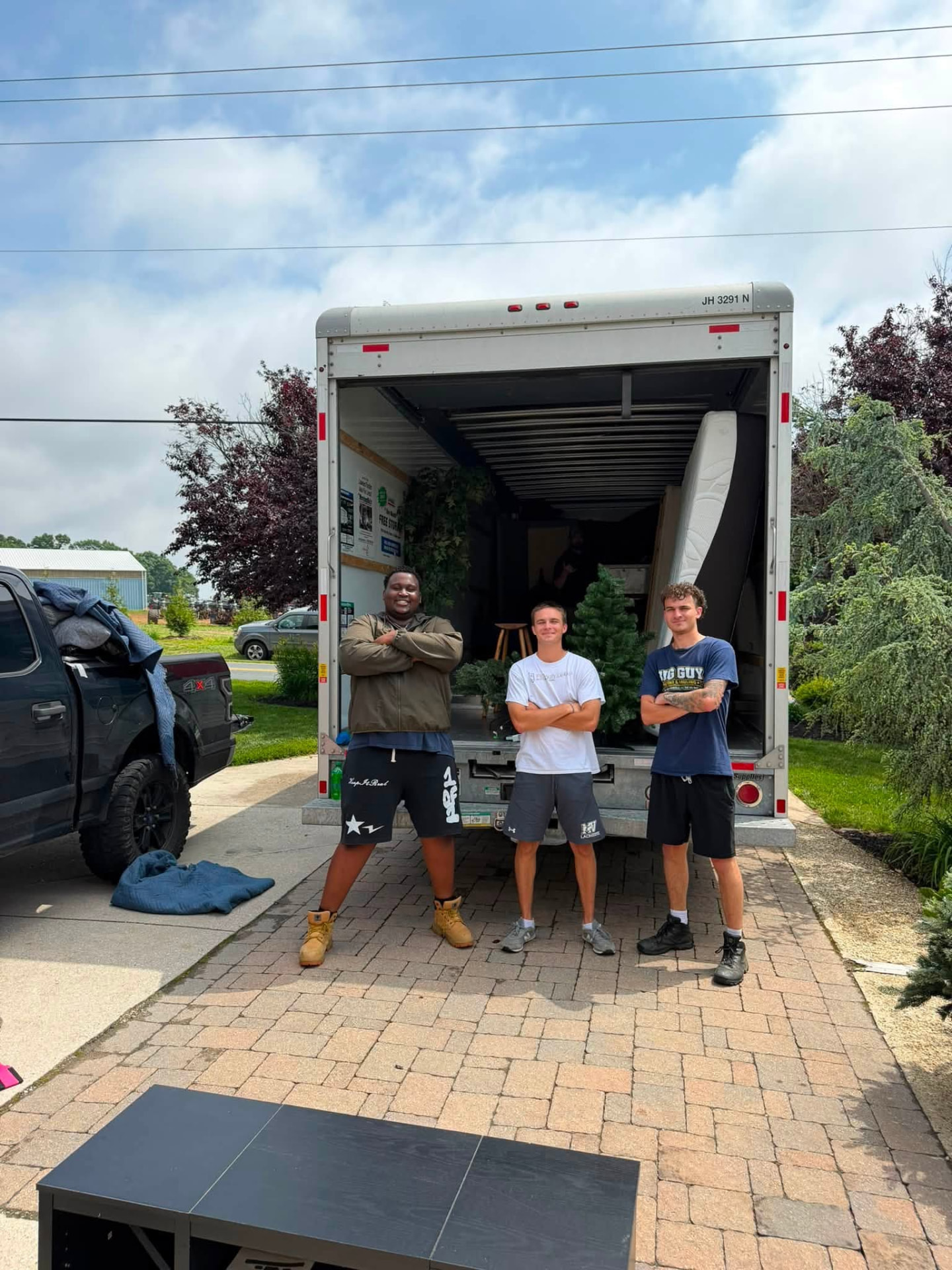Aaron and the Big Guy Moving crew standing at the back of a loaded box truck in Westminster, MD