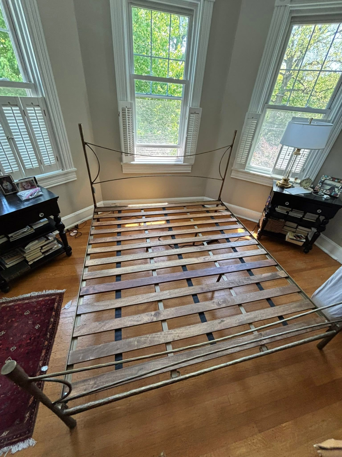 Antique iron bed reassembled in a sunny bedroom