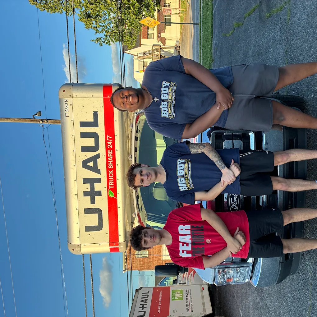 Big Guy Moving crew of three in company shirts in front of a U-Haul truck
