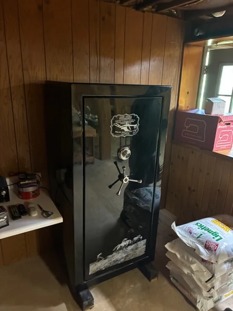 Gun safe standing in a wood-paneled basement