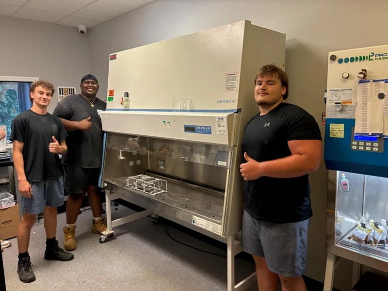 Crew with a biosafety cabinet inside a medical lab