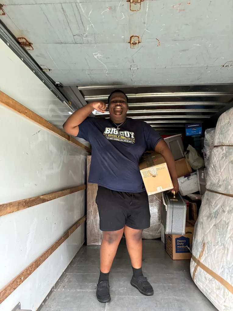 Crew member smiling with a box inside the truck