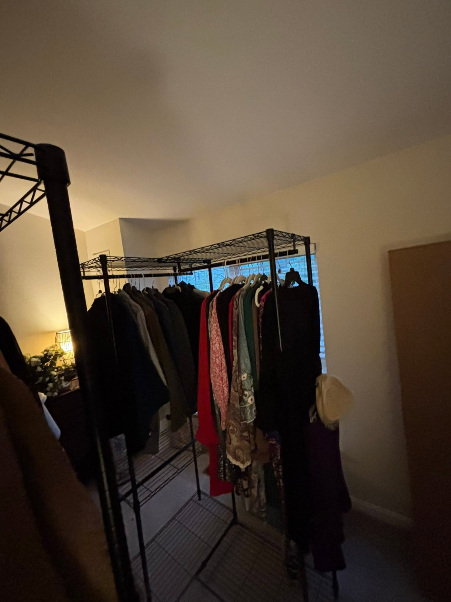 A wardrobe rack of hanging clothes moved without folding