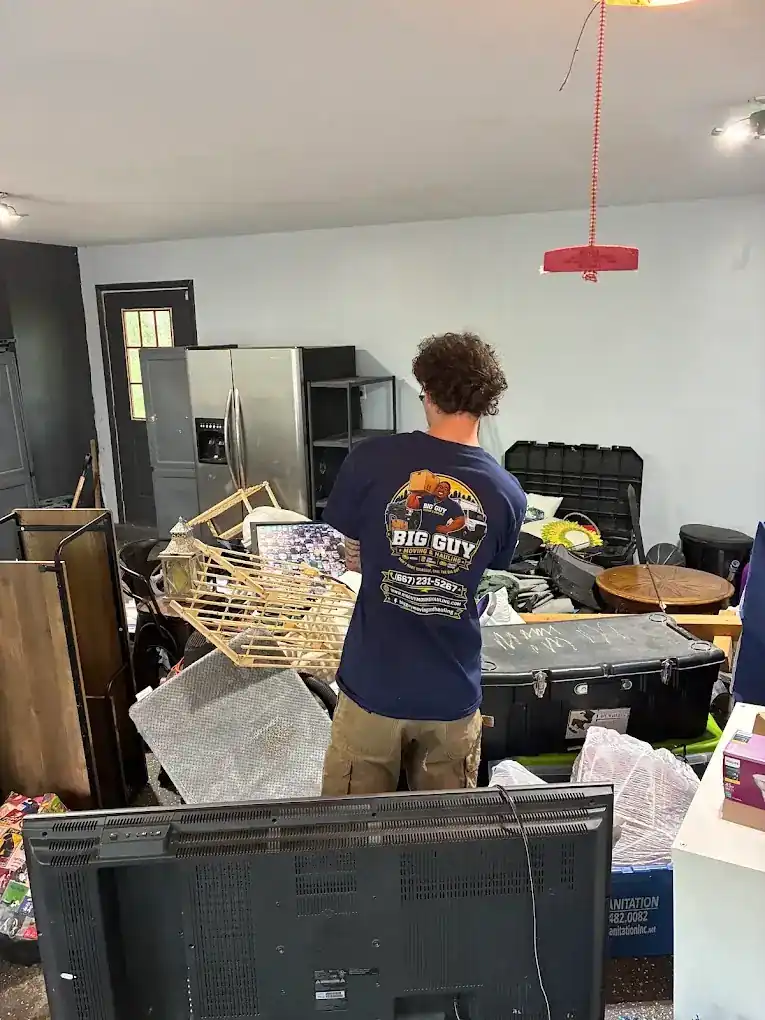 Big Guy Moving crew member sorting a packed garage during a cleanout