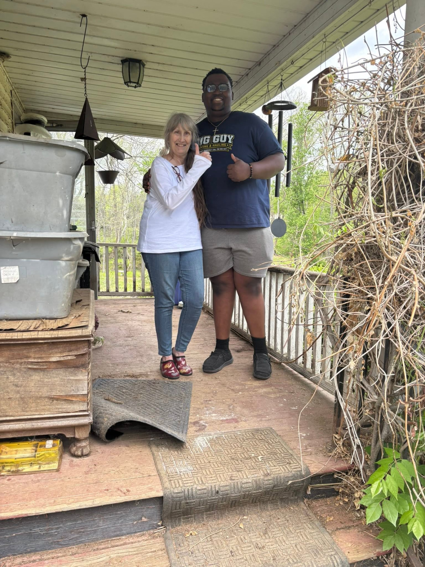 Aaron of Big Guy Moving & Hauling with a happy customer on her porch after a move